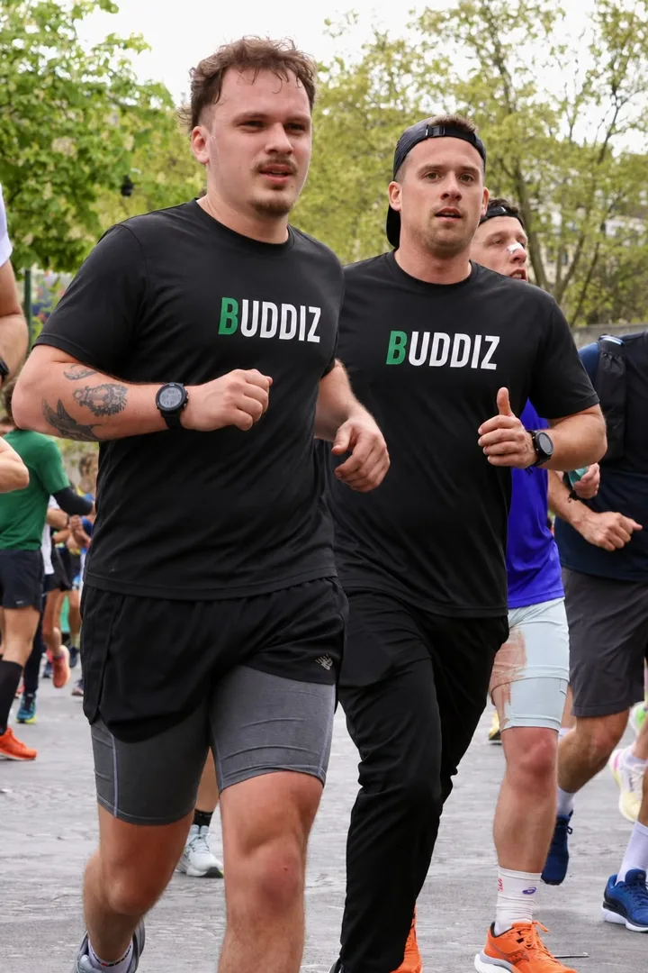 Romain et Valentin, les fondateurs de Buddiz, courent côte à côte en t-shirt Buddiz pendant une course.