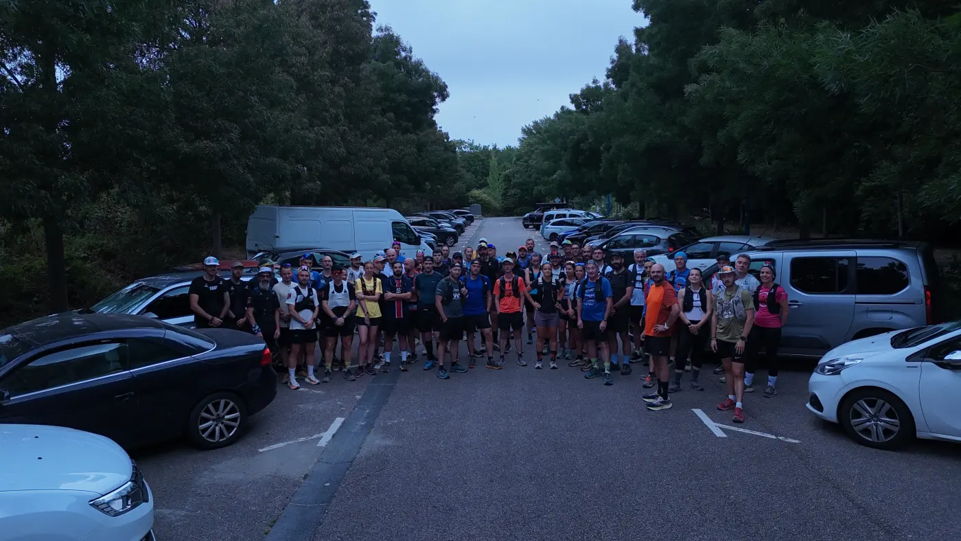 Une soixantaine de coureurs réunis sur un parking en lisière de forêt, juste avant de partir courir ensemble